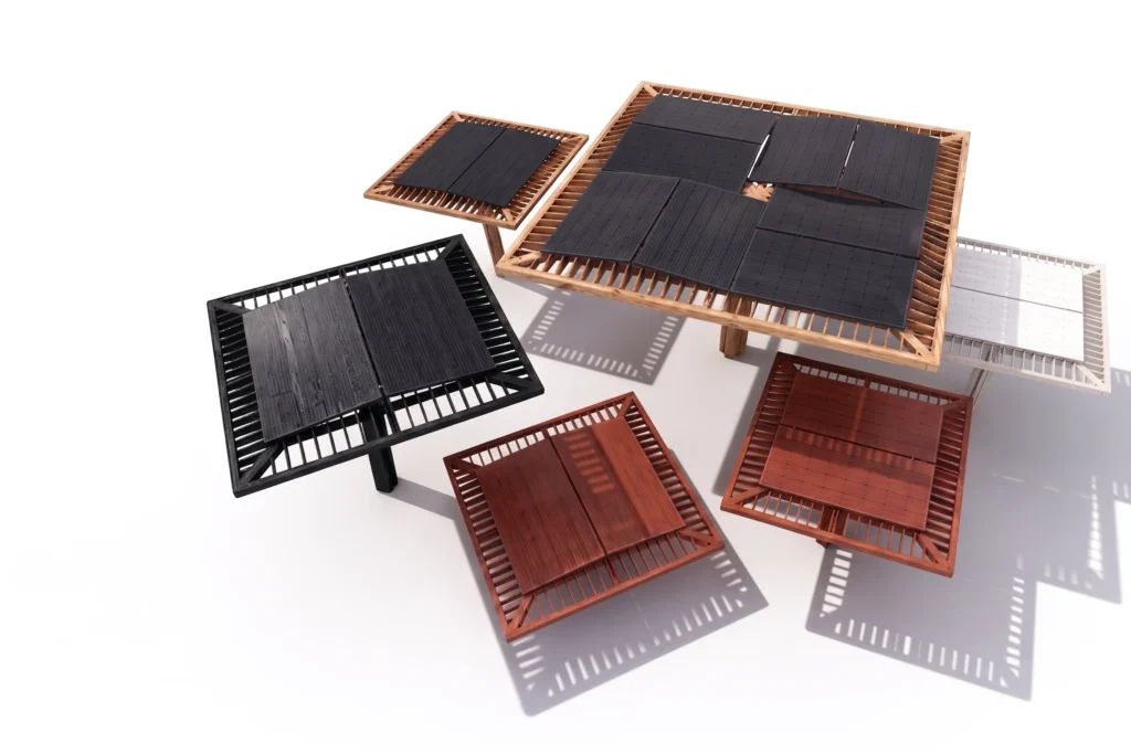 Assorted small solar panels placed on wooden frames, black cells on a white background with shadows.