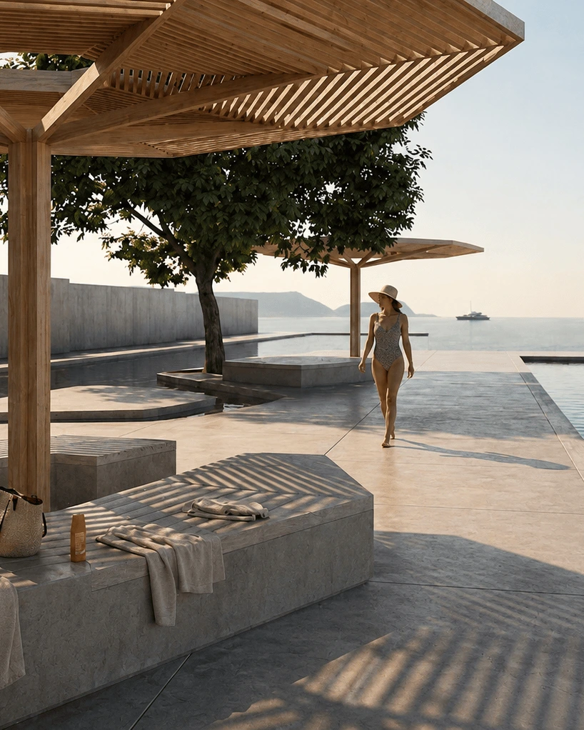 Woman in a swimsuit walking along a poolside deck by the sea under wooden pergolas, towels laid on stone benches.
